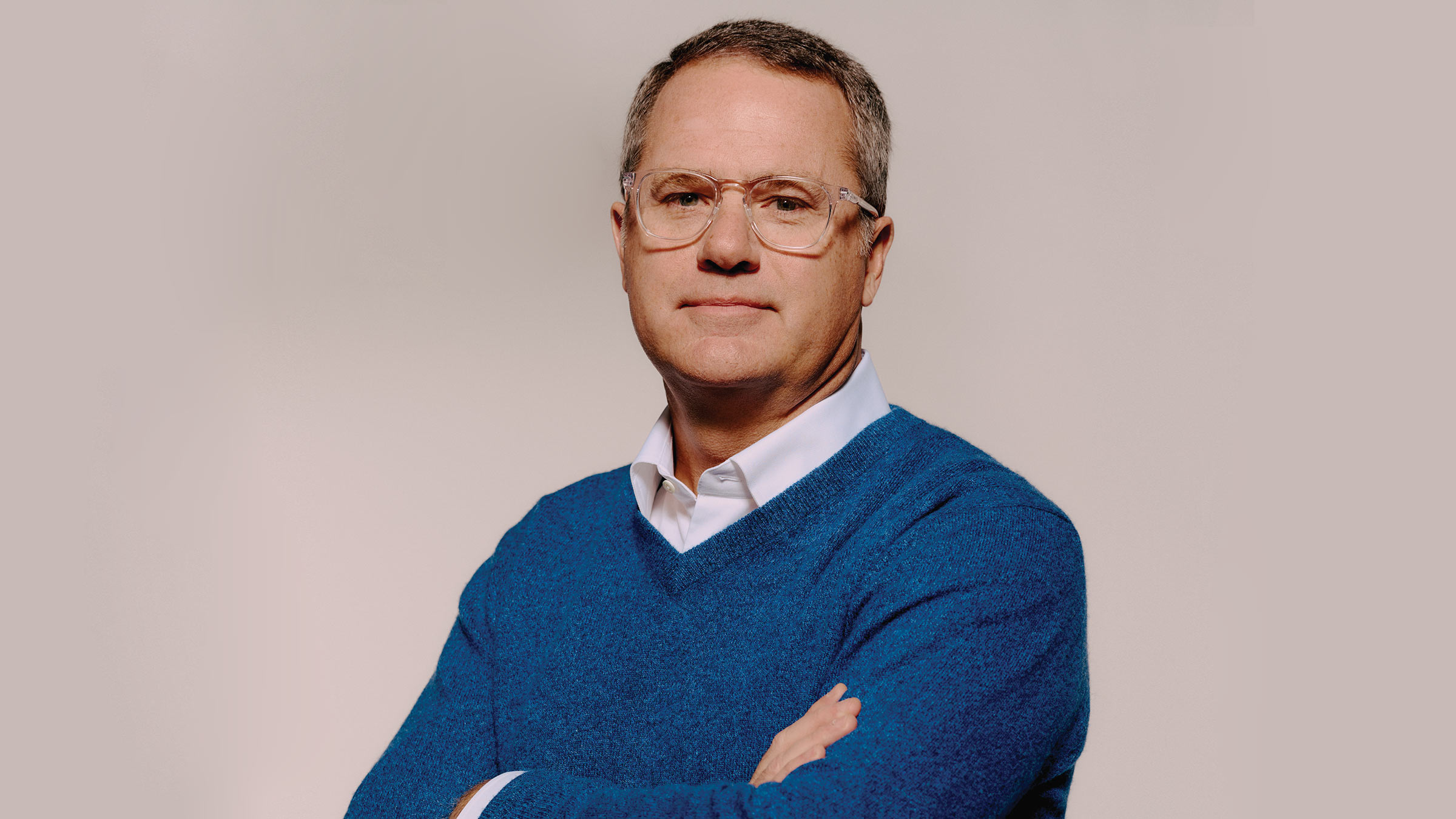 Photograph of Doug McMillon, standing with his arms crossed and looking straight ahead.